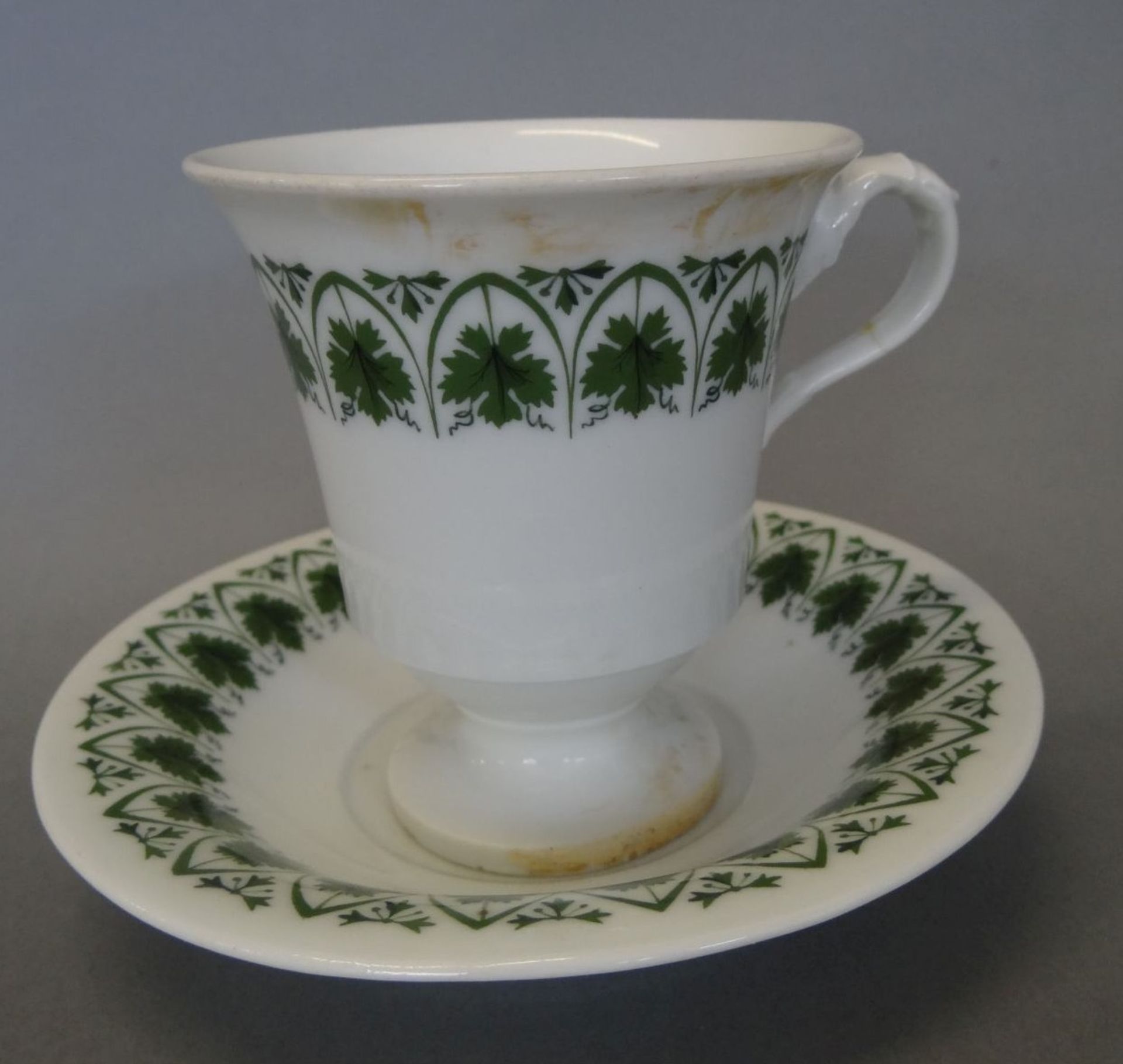 Tasse mit U.T. "Meissen" 19.Jhd., Weinlaub,. Glasur verfärbt, Henkel gekleb