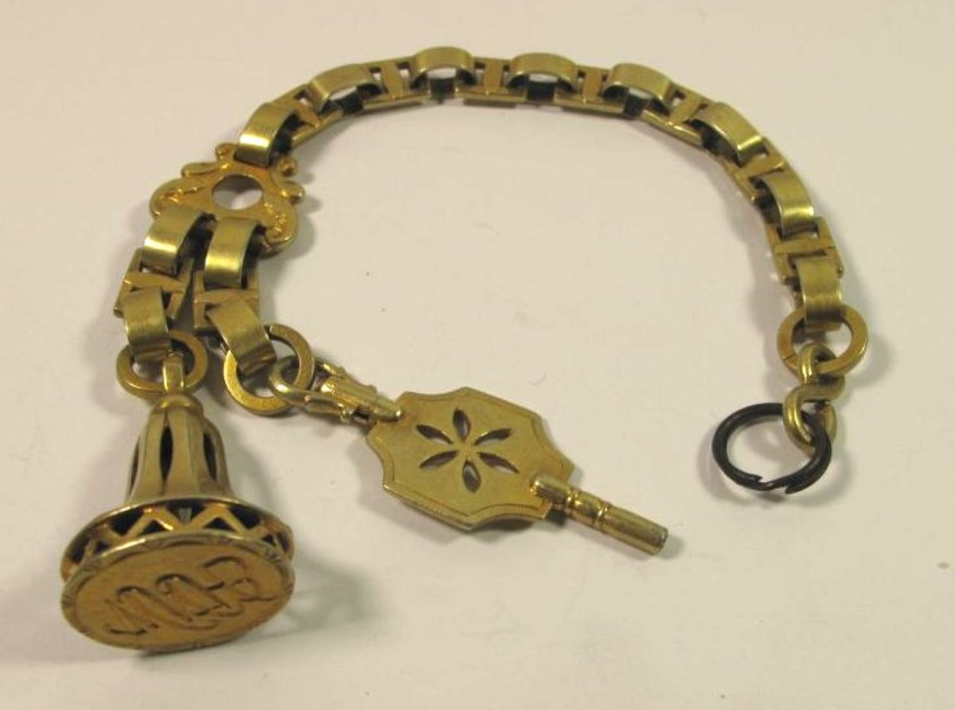 Petschaft und Uhrenschlüssel an Kette, 19. Jhd., vergoldet, L-22,5cm.