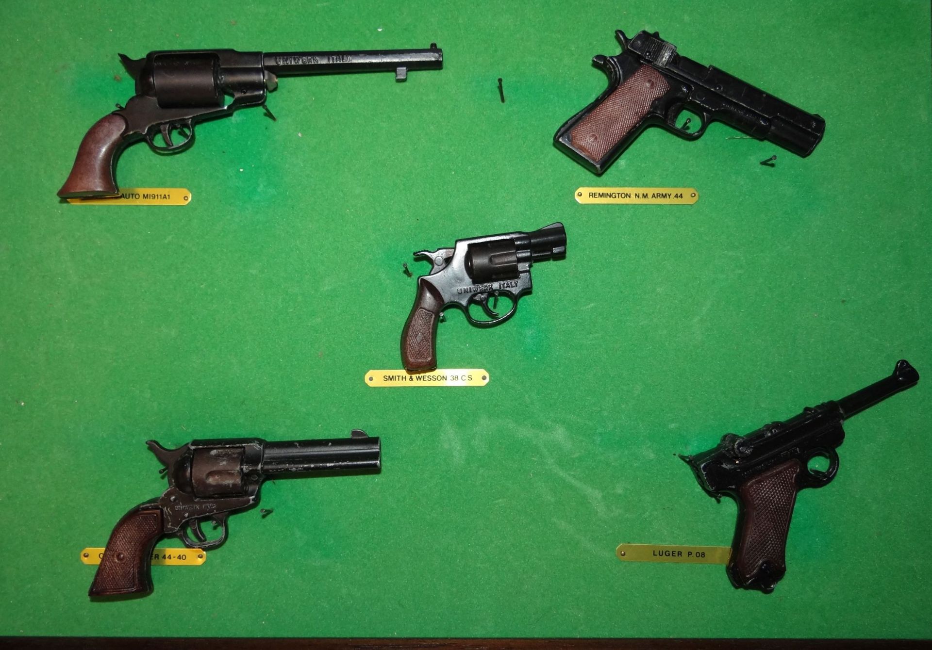4x kl. originalgetreue Miniatur-Pistolen/Revolver, gerahmt, RG 25x36 cm, L-von 6 bis 13,5 cm