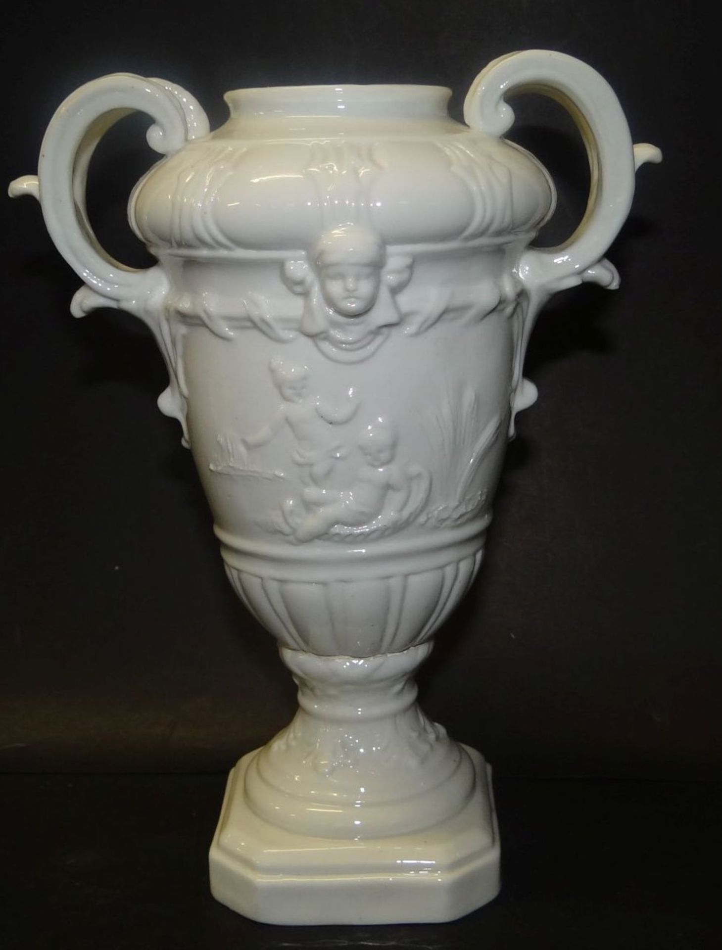 Henkelvase auf Podest, "Fürstenberg" 19. Jhd., weiss, mit Putti-Relief, H-18 c