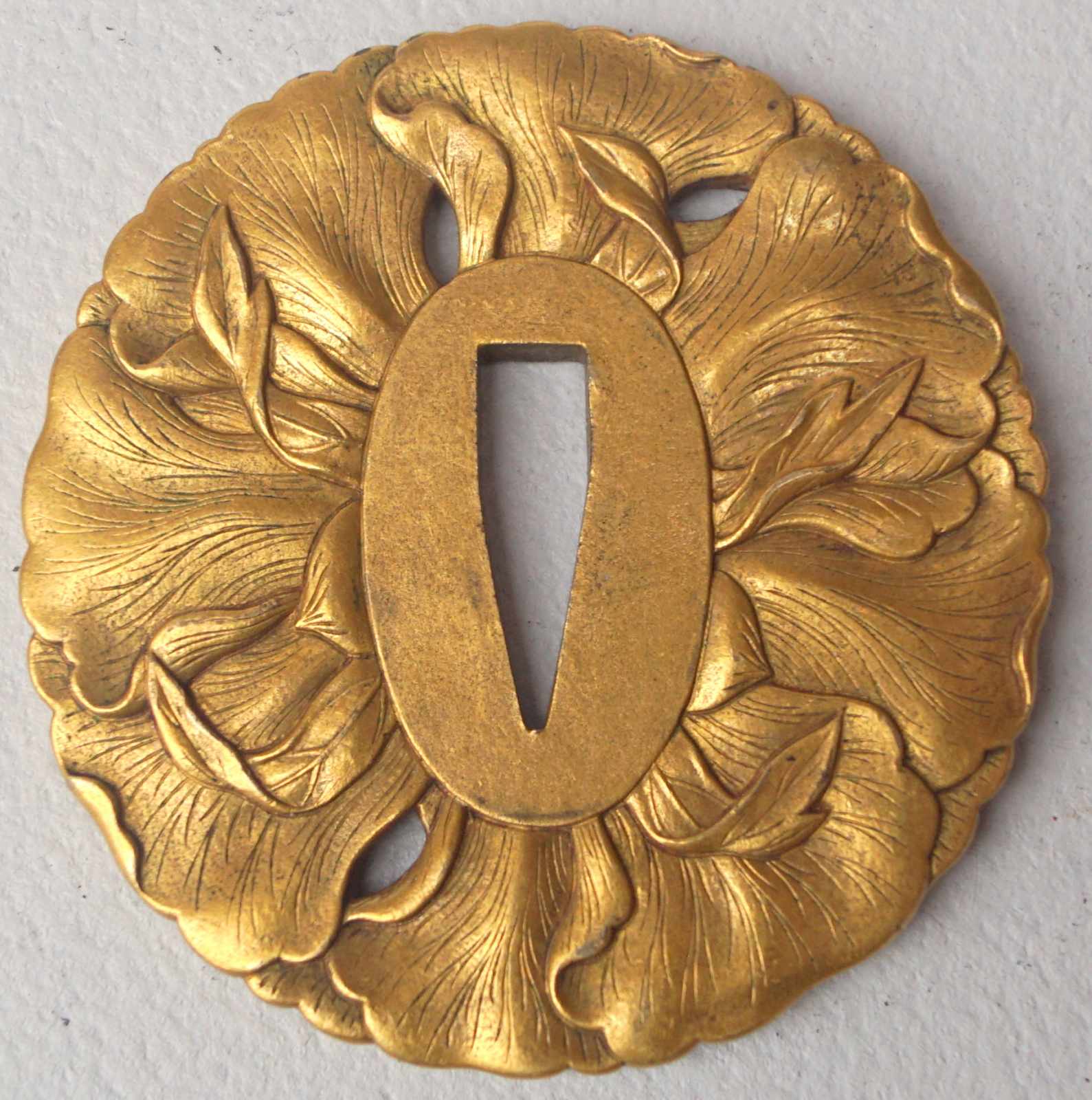 Tsuba Bronze vergoldet, signiert, 19. Jh. Rund mit beidseitigem Flachrelief einer geöffneten