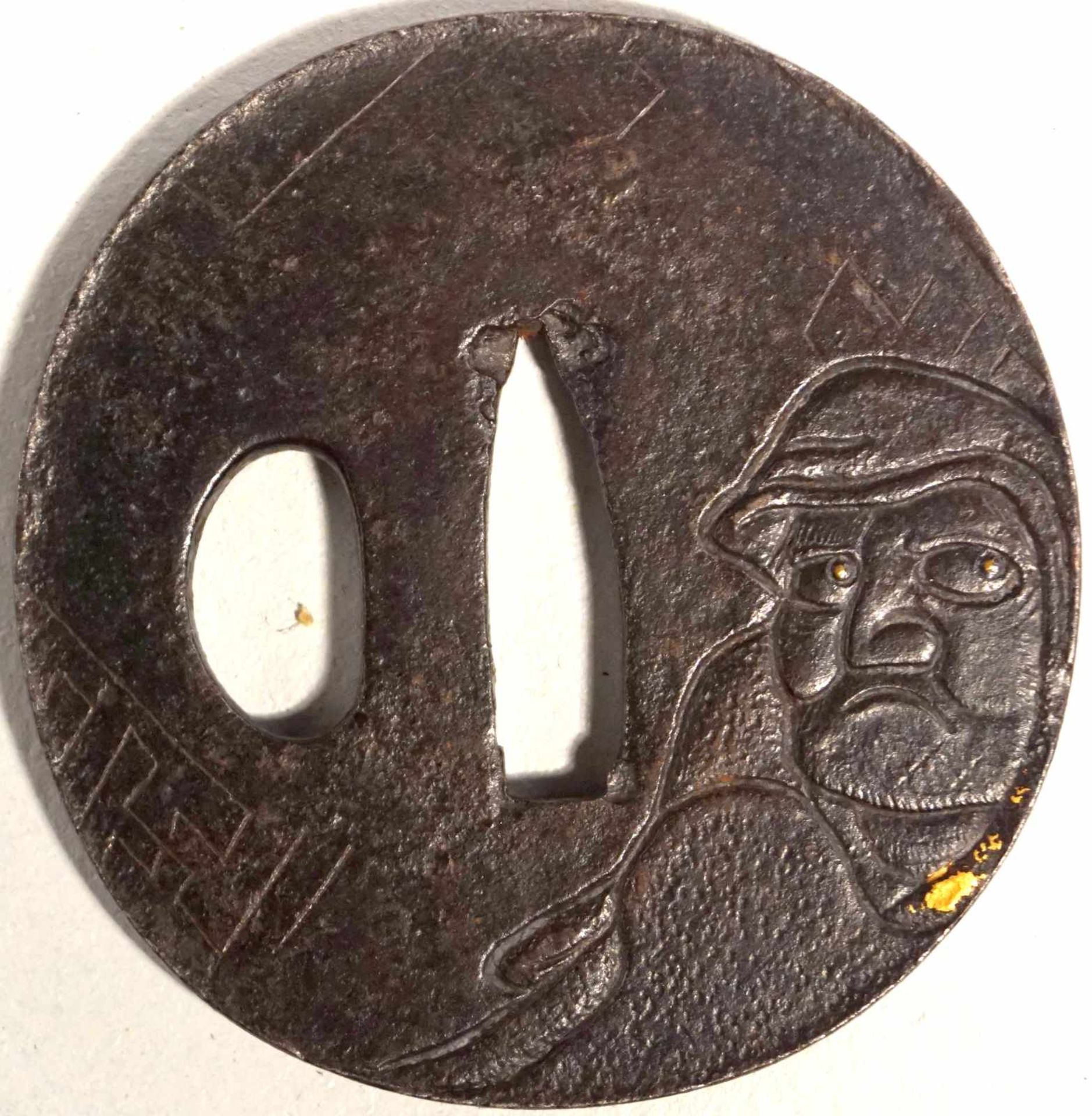 Tsuba, Eisen, Edo Zeit 18/19. JH. Rund mit Mönchsdarstellung und Relief, Goldhöhung der Pupillen und