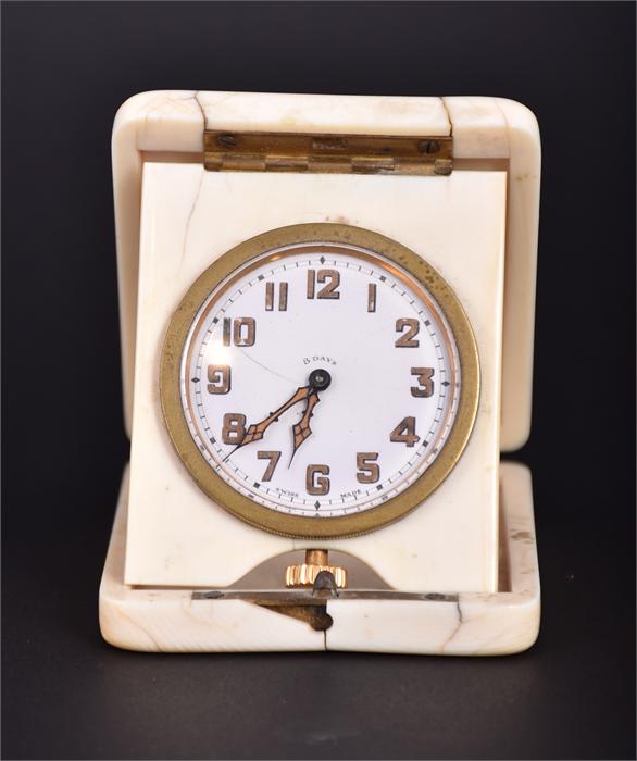 A 1920s ivory cased travelling clock the white enamel dial with luminescent hands and Arabic