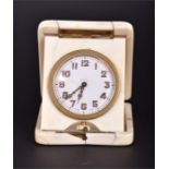 A 1920s ivory cased travelling clock the white enamel dial with luminescent hands and Arabic