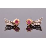 A pair of yellow metal, diamond, and ruby starburst screw-back earrings each with a round cut ruby