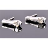 A pair of white metal and diamond drop earrings, each set a single round cut diamond, the stones