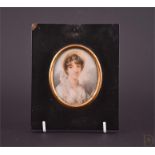 An early 19th century portrait miniature of a young lady wearing a hat, painted on ivory in an