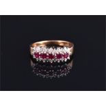 A 9 carat yellow gold, diamond, and ruby ring set with five oval cut rubies flanked by lines of