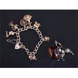 A silver charm bracelet, hung with various charms including a flamenco dancer, an owl, a scooter,