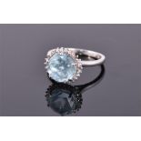 A 9 carat white gold, diamond, and topaz ring, set with a round cut ice blue topaz surrounded by