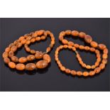 Two amber coloured bead necklaces with graduated ovoid beads. (2)