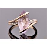 A 9 carat yellow gold, kunzite, and diamond crossover ring, set with a marquise cut pale lilac