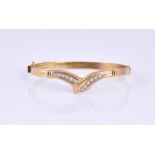 An 18 carat yellow gold and diamond set crossover bangle set with twelve round cut diamonds of