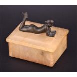 A 1930s onyx trinket box the top mounted with a bronze of a nude girl reading, 12.5cm wide.