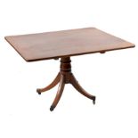 A Regency mahogany tilt top breakfast table the flame top supported on a turned column, to four