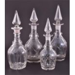 A collection of four mid Victorian clear cut glass decanters in the Gothic Revival style, with