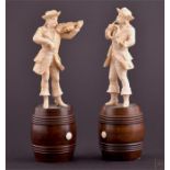 A pair of 19th century European carved ivory figures of street musicians one playing a violin, the