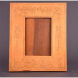 An early 20th century olive wood photograph frame inlaid with cherubs, ribbons, masks, and rams,