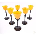 A set of six 1930s coloured glass drinking glasses the vivid yellow glass bell shaped bowls, with