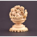 A late 19th century carved ivory group of Cupid & Psyche surrounded by floral garlands, and