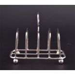 A Victorian silver toast rack of rectangular form, supported on bun feet, hallmarked Chester 1897,