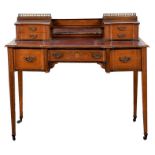 An Edwardian rosewood inlaid writing desk by Maple & Co. the top with a pair of hinged flaps opening