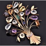 A large yellow metal and multi-gemstone floral spray brooch, set with various coloured topaz,