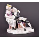 A 19th century Furstenberg porcelain group of a courting couple the couple embracing and seated on