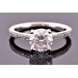 A white metal and diamond engagement ring set with round cut central diamond of approx. 1.50 carats,