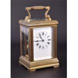 An early 20th century brass repeating carriage clock the white enamel dial with black Roman