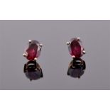 A pair of 9ct yellow gold and rhodalite garnet ear studs each set with an oval faceted garnet, the