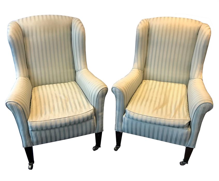A pair of 19th century winged armchairs upholstered in green striped damask fabric, with square