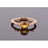 A 9ct yellow gold, diamond and sphene ring centred with a round cut sphene of approximately 1.0 cts,