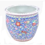 A large 20th century Chinese famille rose fish bowl  decorated with flowers on a blue enamel ground,