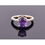 An unusual 18ct white gold, diamond and purple sapphire ring set with an oval cut sapphire of