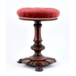 A Victorian carved rosewood piano stool with buttoned red velvet upholstered swivel seat,