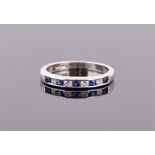 An 18ct white gold, diamond and sapphire band ring channe- set with four diamonds alternated with