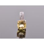 A 9ct yellow gold, diamond and citrine pendant set with a cushion cut lemon yellow citrine,