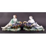 A pair of Continental majolica basket figures formed as a reclining young man and young woman,