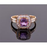 A 9ct yellow gold, diamond and amethyst ring the cushion cut central stone within a rounded square