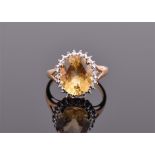 A 9ct yellow gold, golden beryl and diamond oval cluster ring set with a golden beryl measuring 12