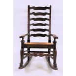 A country oak ladder back rocking chair circa 1900, with wicker seat and turned stretcher, 54 cm