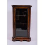 An Edwardian walnut music cabinet  with a single glazed door enclosing four shelves, supported on