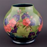 A modern Moorcroft vase with a St Des pattern of pink and blue flowers on a green background, marked