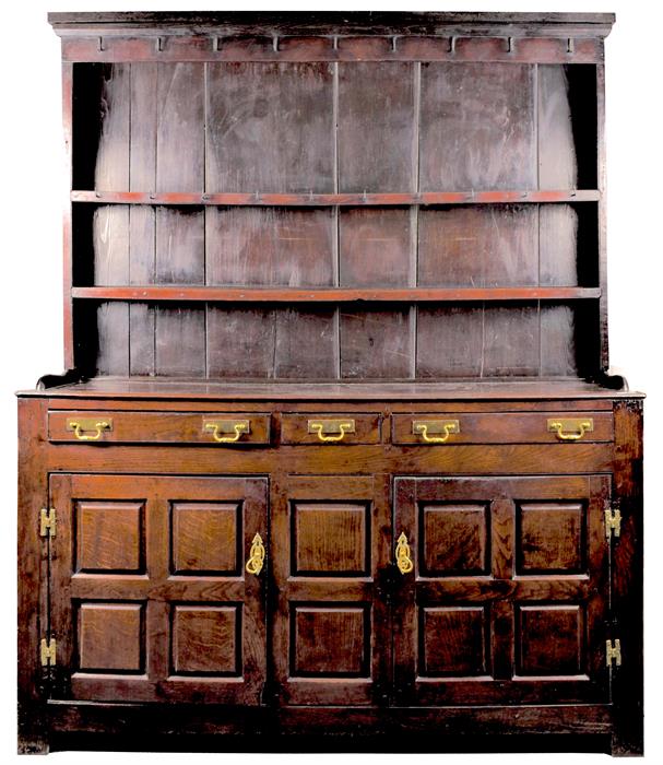 An 18th century Welsh oak dresser with three drawers above two panelled cupboard doors opening to