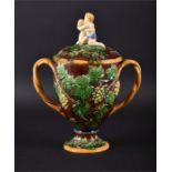 A late 19th century majolica two-handled cup and cover  decorated with grapes and vines, with twin-