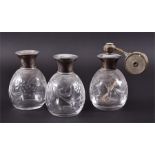 A set of three silver topped glass scent bottles  One with atomiser attached to lid, tallest 12