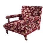 A Victorian walnut low upholstered armchair by Holland & Sons  the arms supported on turned show