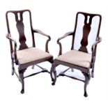 A pair of Georgian oak elbow chairs with upholstered drop-in seats and scrolling cabriole forelegs