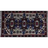 A fringed Turkish Kelim wool rug  the ivory field interspersed with symmetrical geometric medallions